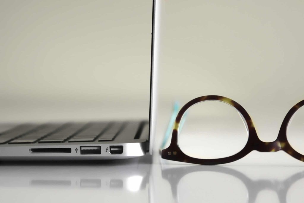 black framed eyeglasses beside laptop computer
